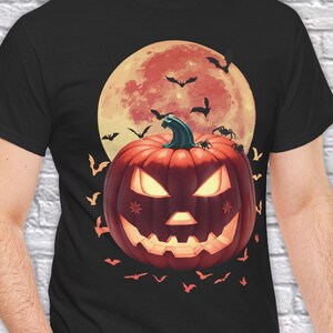 May include: Black t-shirt with a graphic of a jack-o'-lantern in front of a red moon with bats flying around it.