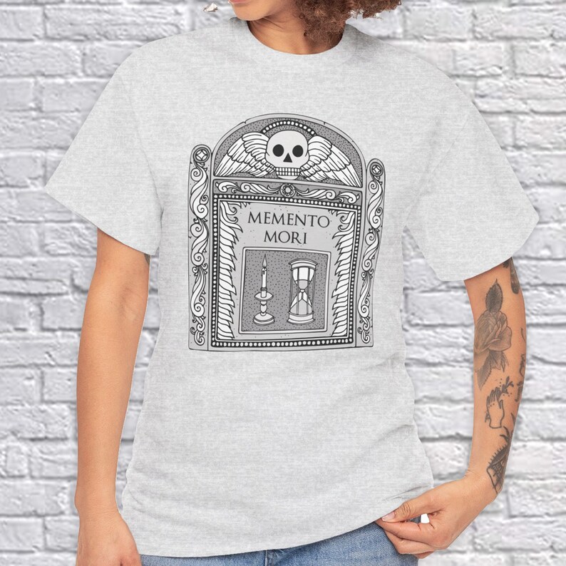 Illustration of a grave stone from the 1800s with a skull, candle, and hourglass on it. States Memento Mori. Design on a t-shirt.