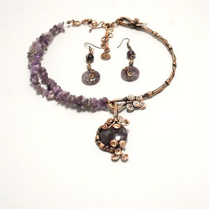 May include: A copper wire necklace with amethyst stones and a pendant. The necklace is paired with matching earrings.