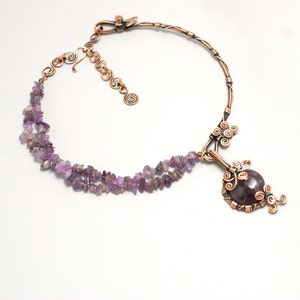 May include: A copper wire necklace with a large amethyst pendant. The pendant is surrounded by copper wire swirls and the necklace is made with a double strand of small amethyst chips.