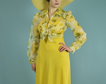 Könnte beinhalten: Eine Frau trägt ein gelbes Maxikleid mit einem floralen Oberteil und einen breitkrempigen Strohhut.