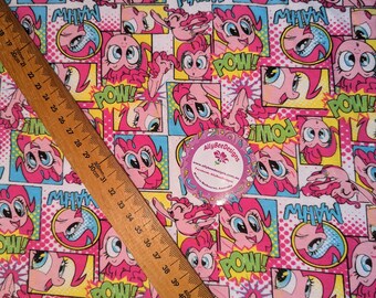 May include: A white fabric with a repeating pattern of pink cartoon ponies with large eyes. The ponies are in comic book style panels with the words "POW!" and "MAHW" in yellow and green.