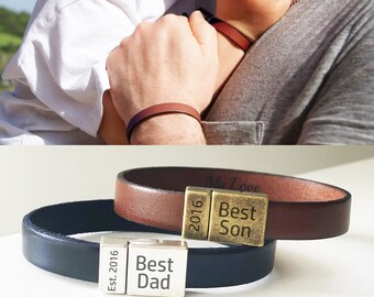 Puede incluir: Dos pulseras de cuero con placas de metal grabadas. La pulsera marrón tiene el texto "My Love Best Son" y "2016". La pulsera negra tiene el texto "Best Dad" y "Est. 2016".