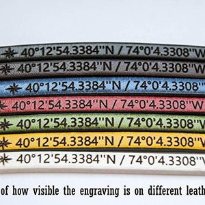 Puede incluir: Primer plano de siete tiras de cuero de diferentes colores, cada una con el mismo texto grabado: "40&deg;12'54.3384"N / 74&deg;0'4.3308"W". Los colores son negro, marr&oacute;n oscuro, azul, rojo, verde, amarillo y blanco. El texto es visible en cada tira, pero la visibilidad var&iacute;a seg&uacute;n el color del cuero.
