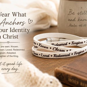 Puede incluir: Una pulsera envolvente blanca con texto negro que dice: Seen, Known, Chosen, Loved, Redeemed, Forgiven, Adopted. La pulsera tiene un cierre de metal plateado y se muestra junto a una taza con el texto Be still and know Psalm 46:10.