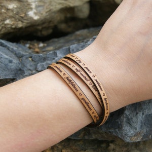 Puede incluir: Un brazalete de cuero de triple vuelta con las palabras "love", "joy", "peace", "patience", "kindness", "goodness", "faithfulness", "gentleness", "self-control" grabadas en &eacute;l.