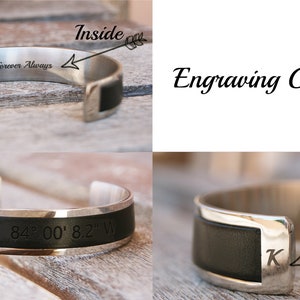 May include: A silver cuff bracelet with a black leather band. The inside of the bracelet is engraved with the words "Forever Always". The front of the bracelet is engraved with the coordinates "#51' 25.7" N 84&deg; 00' 8.2" W". The ends of the bracelet can be engraved with a letter.