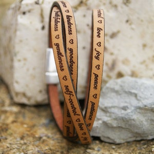Puede incluir: Un brazalete de cuero de triple vuelta con las palabras "paciencia", "paz", "alegr&iacute;a", "amor", "autocontrol", "bondad", "amabilidad", "fidelidad", "mansedumbre" grabadas en &eacute;l.