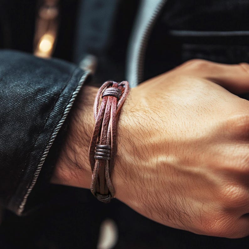 May include: A brown leather bracelet with a braided design and metal accents.