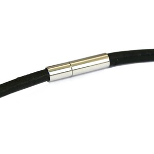 May include: A black leather bracelet with a silver magnetic clasp.