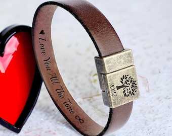 May include: Brown leather bracelet with a magnetic clasp. The bracelet is engraved with the text "Love You All The Time" and a tree with the year 2022.