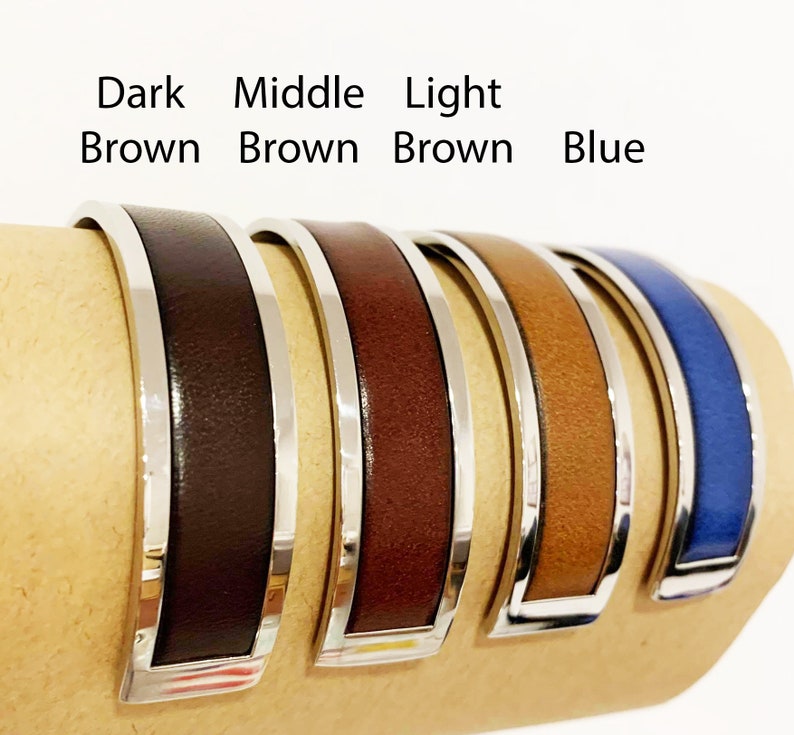 May include: Five leather cuff bracelets in shades of brown and blue, each with a silver-tone metal frame. The bracelets are displayed side by side, with the text "Dark Brown, Middle Brown, Light Brown, Blue" above them.