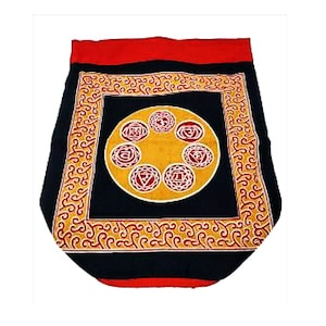 May include: A black and red meditation cushion with a yellow and red mandala design featuring seven chakras. The cushion has a red border and a black center with a yellow circle in the middle.