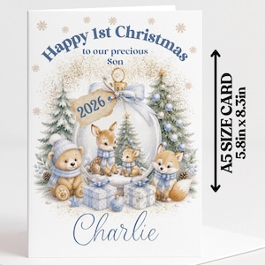 May include: A greeting card featuring the text Happy 1st Christmas to our precious Son and the name Charlie. The illustration shows a bear, a fox, and deer inside a glass ornament with the year 2026. The card measures 5.8 inches by 8.3 inches.