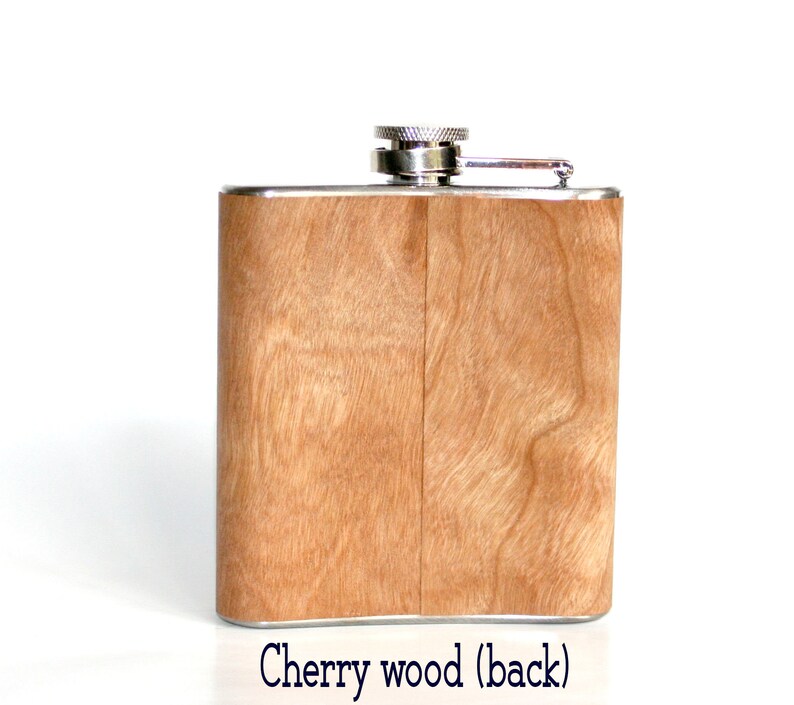 May include: A stainless steel flask with a cherry wood finish. The flask has a silver cap and a hinged lid. The back of the flask is shown in the image.