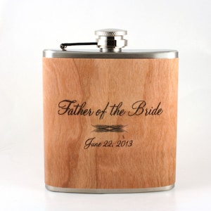 May include: A stainless steel flask with a wood veneer and a personalized inscription that reads "Father of the Bride" and "June 22, 2013".