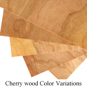 May include: Four pieces of cherry wood veneer showing different color variations. The wood has a natural reddish-brown color with darker and lighter streaks.