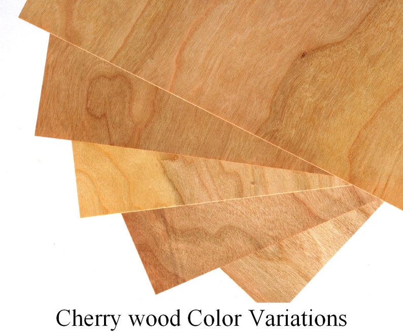 May include: Four pieces of cherry wood veneer showing different color variations. The wood has a natural reddish-brown color with darker and lighter streaks.