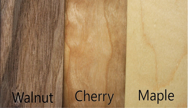 May include: Close-up of three wood samples: walnut, cherry, and maple. The wood grain is visible in each sample.
