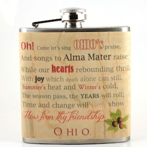 Pu&ograve; includere: Una fiaschetta in acciaio inossidabile con un design a venature di legno e una scritta rossa e nera che recita "Oh! Come let's sing Ohio's praise, And songs to Alma Mater raise; While our hearts rebounding thrill, With joy which death alone can still. Summer's heat and Winter's cold, The season pass, the YEARS will roll; Time and change will surely show How firm thy friendship OHIO."