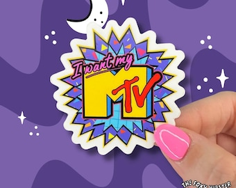 May include: A sticker featuring the MTV logo in yellow and red, with the text "I want my MTV" in pink. The sticker has a white border and a starburst design in blue, purple, and yellow. The background is purple with stars and a crescent moon.