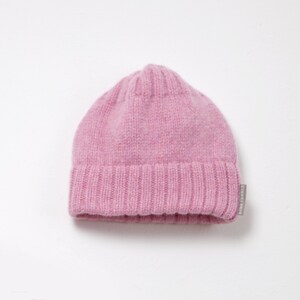 K&ouml;nnte beinhalten: Eine rosa gestrickte M&uuml;tze mit umgeschlagenem Rand.