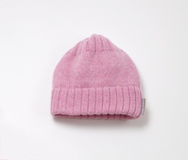 K&ouml;nnte beinhalten: Eine rosa gestrickte M&uuml;tze mit umgeschlagenem Rand.