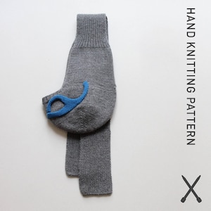Peut inclure: Une chaussette grise tricotée avec un accent bleu, peut-être un protège-talon. La chaussette est présentée verticalement sur un fond blanc. Le texte "HAND KNITTING PATTERN" est imprimé verticalement sur le côté droit de l'image, avec une paire d'aiguilles à tricoter en dessous.
