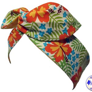 May include: A white headband with a tropical print featuring orange, yellow, and blue hibiscus flowers and green leaves.
