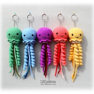 Peut inclure: Cinq porte-clés en forme de méduses au crochet. Chaque méduse a une tête ronde et de longs tentacules bouclés. Les porte-clés sont de couleurs verte, bleue, violette, rouge et jaune. Chaque porte-clés est en métal.