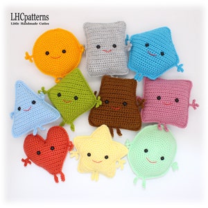 May include: A set of nine crocheted plush toys shaped like different geometric shapes and a heart. The toys are all smiling and have black eyes. The colors of the toys are yellow, gray, blue, green, brown, pink, red, light yellow, and light green.