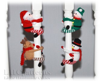 May include: Four crocheted Christmas characters hanging on white banisters. A Santa Claus, a reindeer, an elf, and a snowman are all climbing up the banisters.  The characters are all wearing red and white striped stockings.