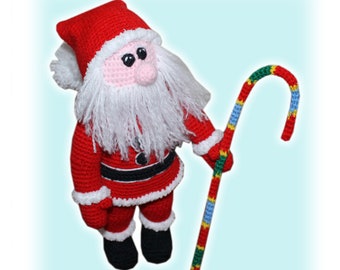 May include: A crocheted Santa Claus doll wearing a red suit with white trim and a white beard. He is holding a candy cane walking stick with red, green, blue, and yellow stripes.