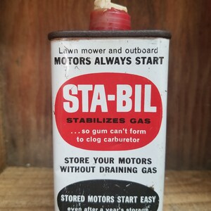 May include: A red and white metal can with a white spout. The can is labeled "STA-BIL STABILIZES GAS ... so gum can't form to clog carburetor STORE YOUR MOTORS WITHOUT DRAINING GAS STORED MOTORS START EASY even after a year's storage".
