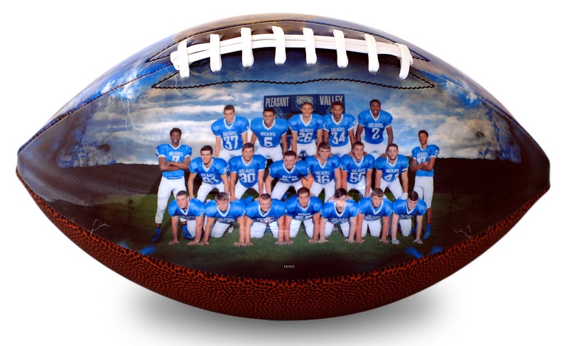 Op de afbeelding: Een voetbal met een foto van een voetbalteam dat blauwe shirts draagt met witte nummers. Het team staat voor een bord met de tekst "Pleasant Valley Bears".