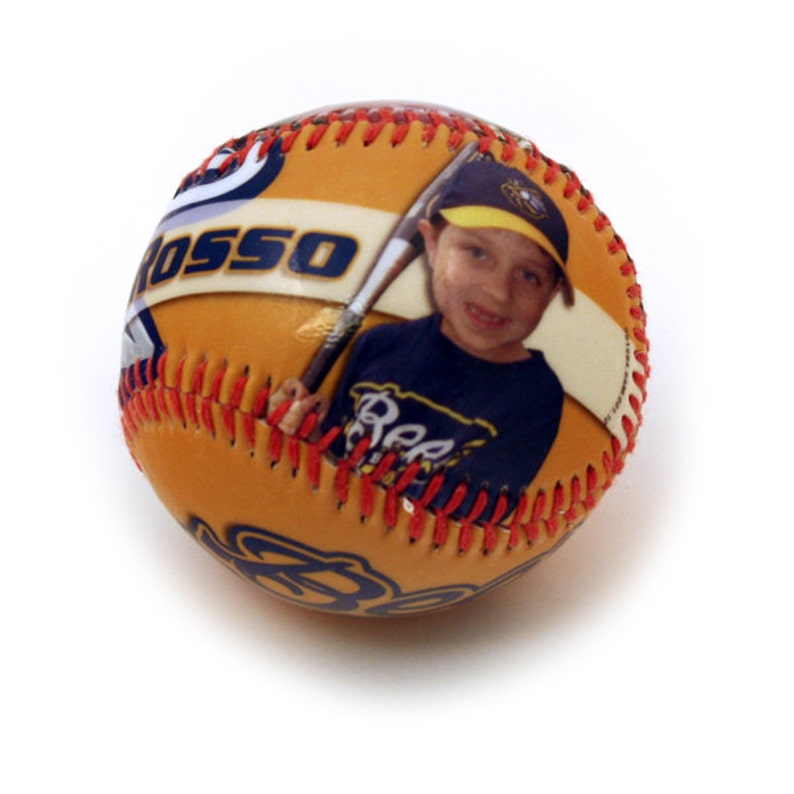 May include: A yellow baseball with red stitching and a photo of a young boy holding a bat. The boy is wearing a blue and yellow baseball uniform with the word "Bees" on the front. The baseball has the name "ROSSO" printed on it.