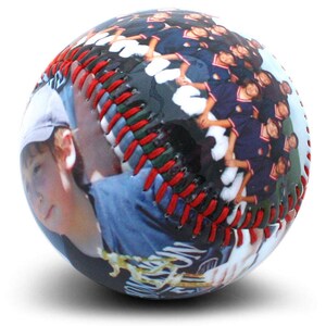 May include: A baseball with a photo of a young person and a group of people wearing blue and red uniforms. The baseball has red stitching.