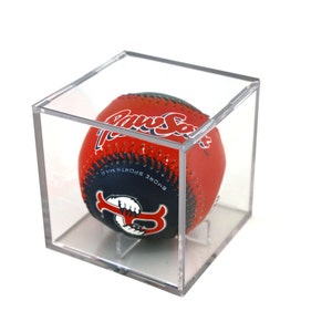 May include: A red, white, and blue baseball with "Paw Sox" written on it in white lettering. The baseball is in a clear plastic display case.