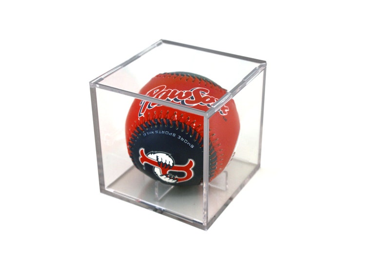May include: A red, white, and blue baseball with "Paw Sox" written on it in white lettering. The baseball is in a clear plastic display case.