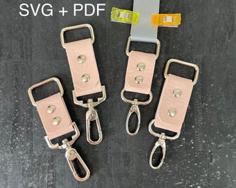 May include: Four pink leather keychains with silver swivel clips. Each keychain has two silver rivets. The keychains are arranged on a black surface. SVG + PDF text is in the top left corner of the image.