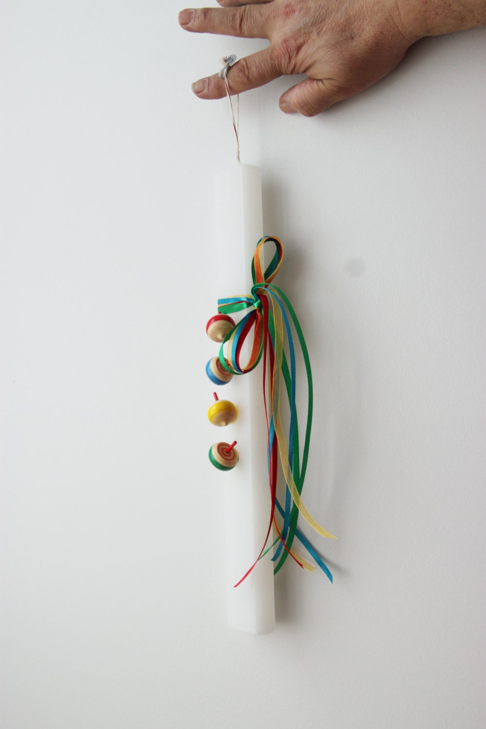 Spinning tops Easter candle, wooden spinning tops on flat, white candle