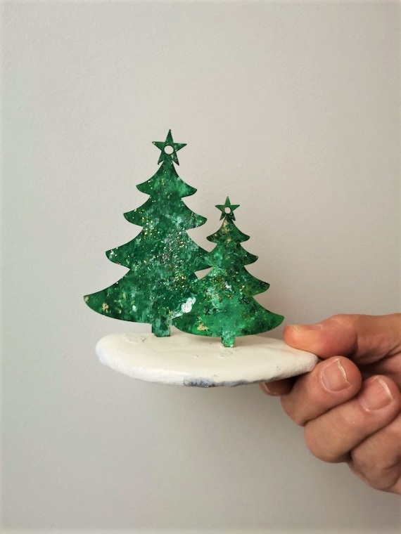 Two Chistmas trees, two wooden Xmas trees on stone, big and small Christmas trees, green sparkling Christmas trees set on tumbled stone