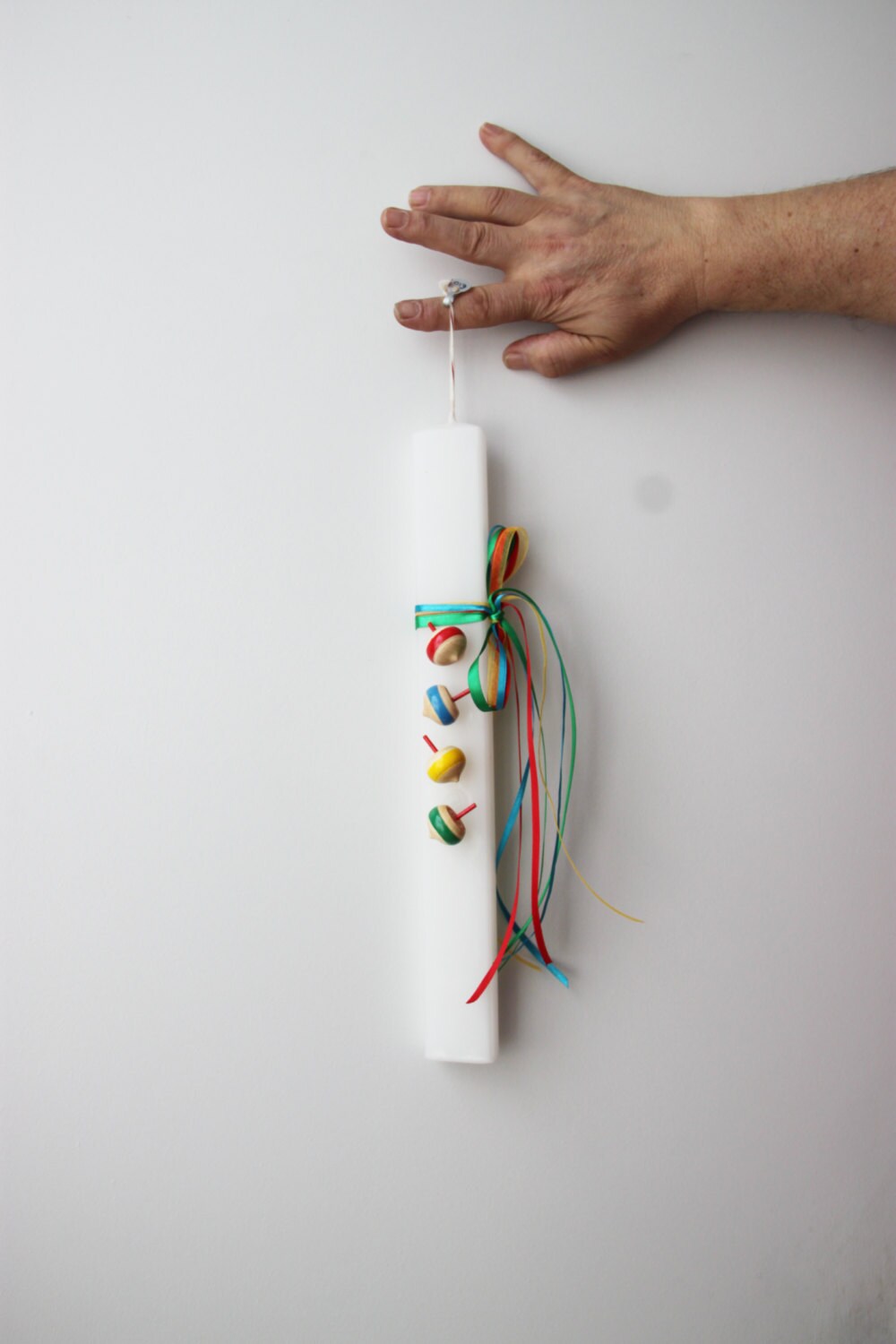 Spinning tops Easter candle, wooden spinning tops on flat, white candle