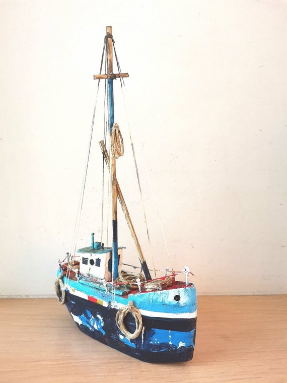 Wooden blue sailboat, colourful sailboat of wood, metal, twine, etc, handmadehand built, Greek rustic sailboat