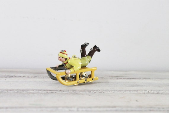 Yellow sled vintage tree ornament with child in winter clothes, yellow sled old toy style, vintage collectible miniature, tree ornament