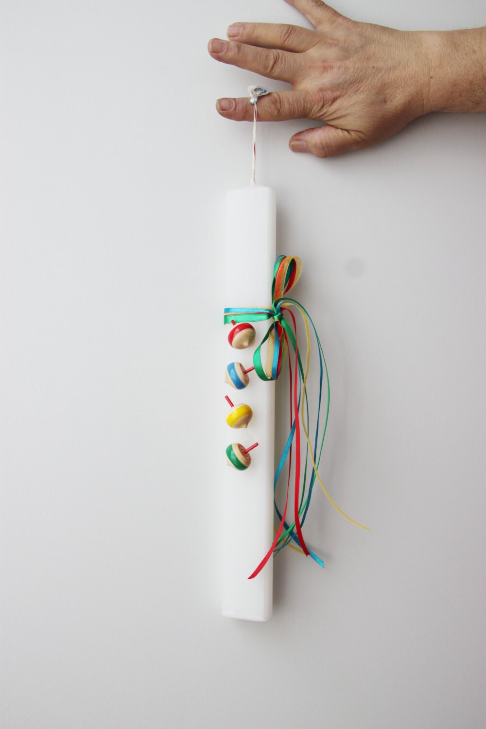 Spinning tops Easter candle, wooden spinning tops on flat, white candle