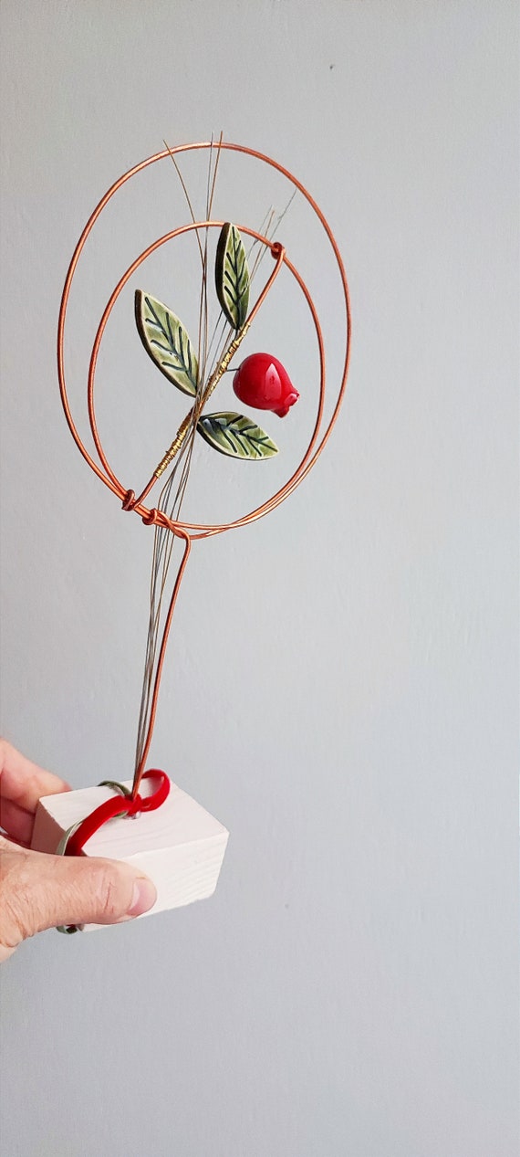 Pomegranate wreath art object, small pomegranate wreath of clay and copper wire on square, ceramic base with green leaves