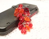 Rote Telefon-Charme. Telefon-Zubehör. Grünen und gelben Handyanhänger. Schwarz und weiß-Telefon-Dekor