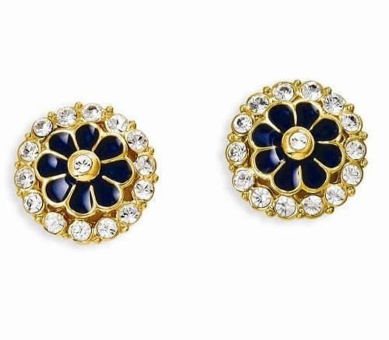 May include: A pair of gold tone earrings with a blue enamel flower design surrounded by clear rhinestones.