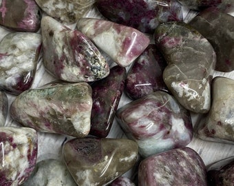 May include: A collection of tumbled pink and grey stones with white and grey swirls. The stones are smooth and polished.